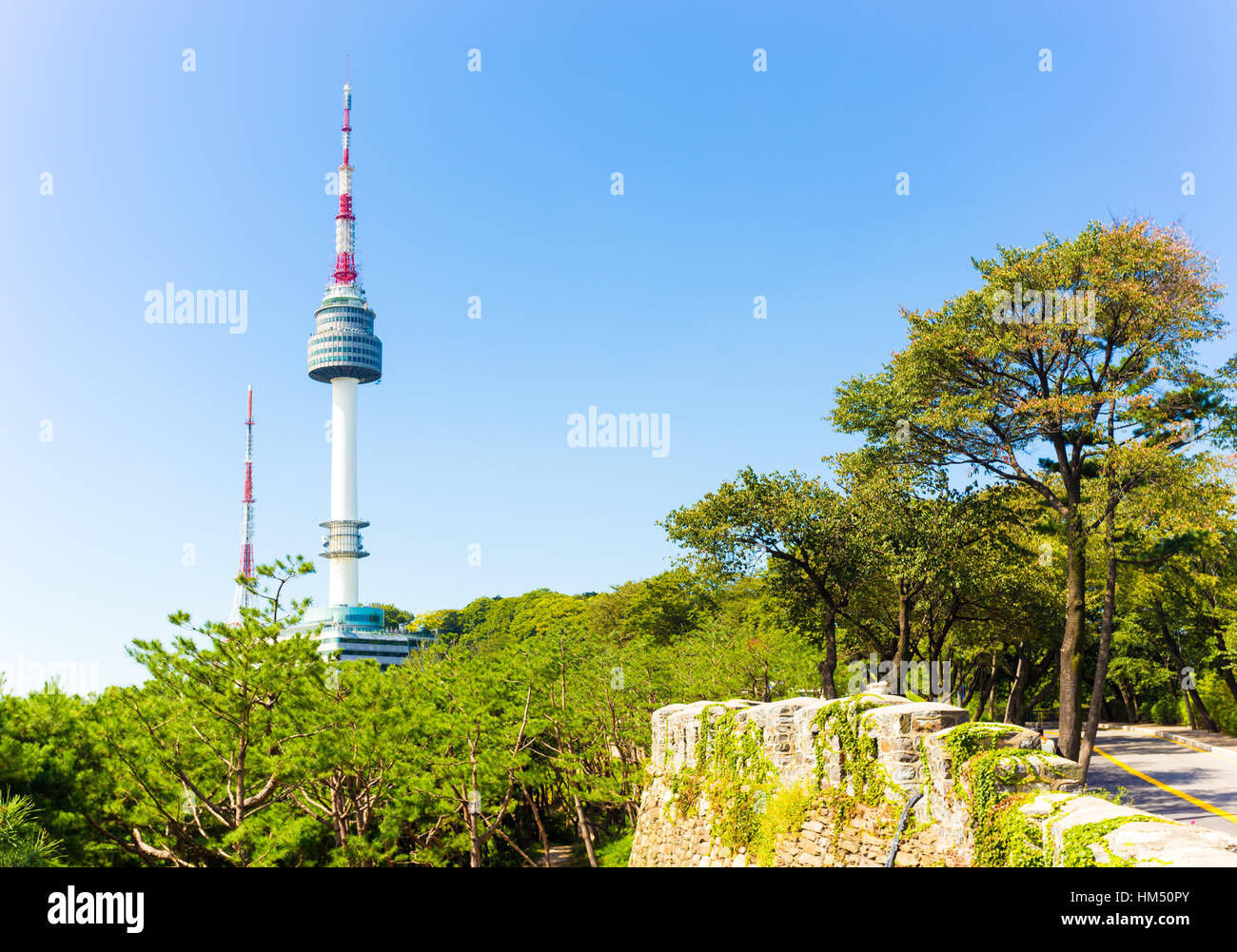 Alte Stadtmauer und Bäume im Vordergrund mit freier Sicht auf N Seoul Tower broadcast Antenne am Namsan Berg an einem klaren, blauen Himmel Stockfoto