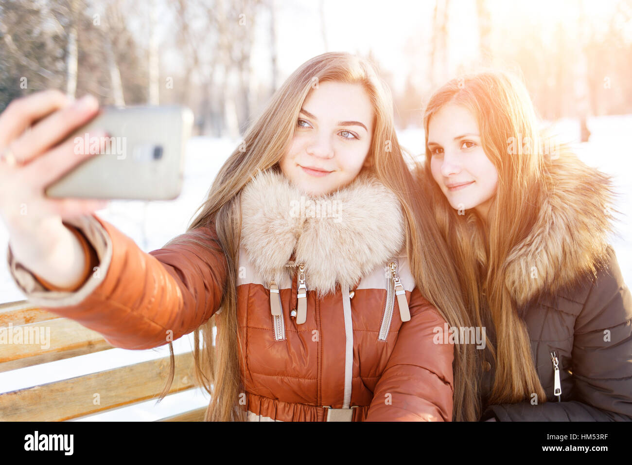 Zwei lächelnde Mädchen machen Selfie in Winter park Stockfoto
