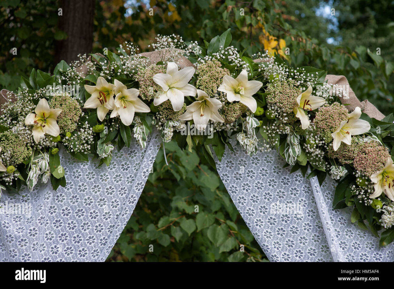 Hochzeit Bogen mit weißen Blumen Lilien verziert Stockfoto