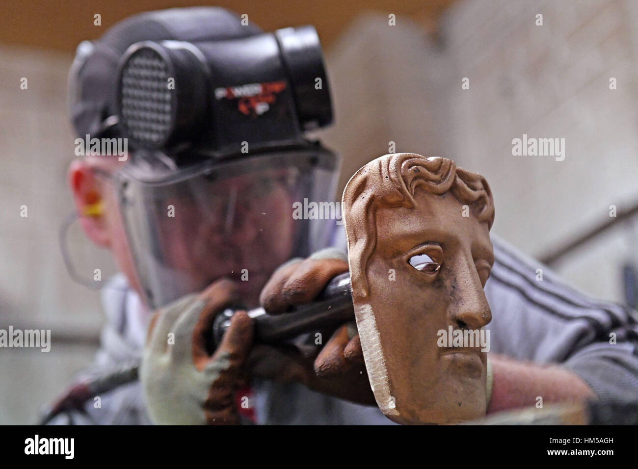 Den letzten Schliff zu einer BAFTA-Maske bei neuen Pro Gießereien in West Drayton, Middlesex, vor die Zeremonie noch in diesem Monat erfolgen. Stockfoto