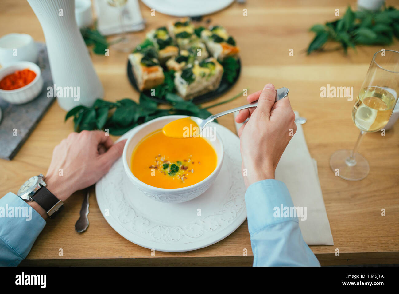 Bild des Mannes mit Kürbissuppe am Esstisch beschnitten Stockfoto