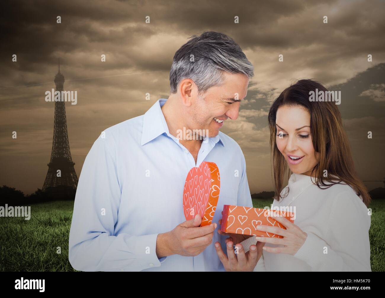 Mann Frau mit Eiffelturm im Hintergrund Geschenk anzubieten Stockfoto