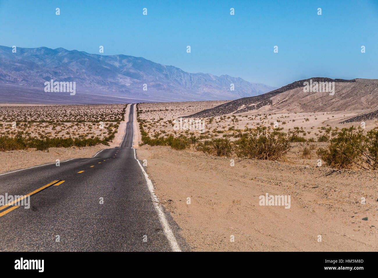 Endlose US Highway zum Death Valley Nationalpark, Kalifornien - Bild auf einem Motorrad Roadtrip durch den Westen der USA Stockfoto