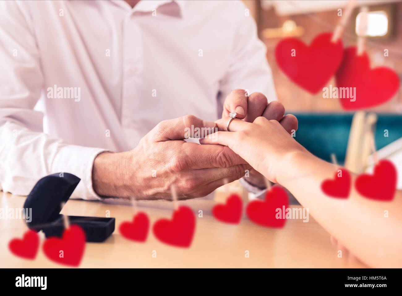 Zusammengesetztes Bild des romantischen Paares den Austausch von Ringen Stockfoto