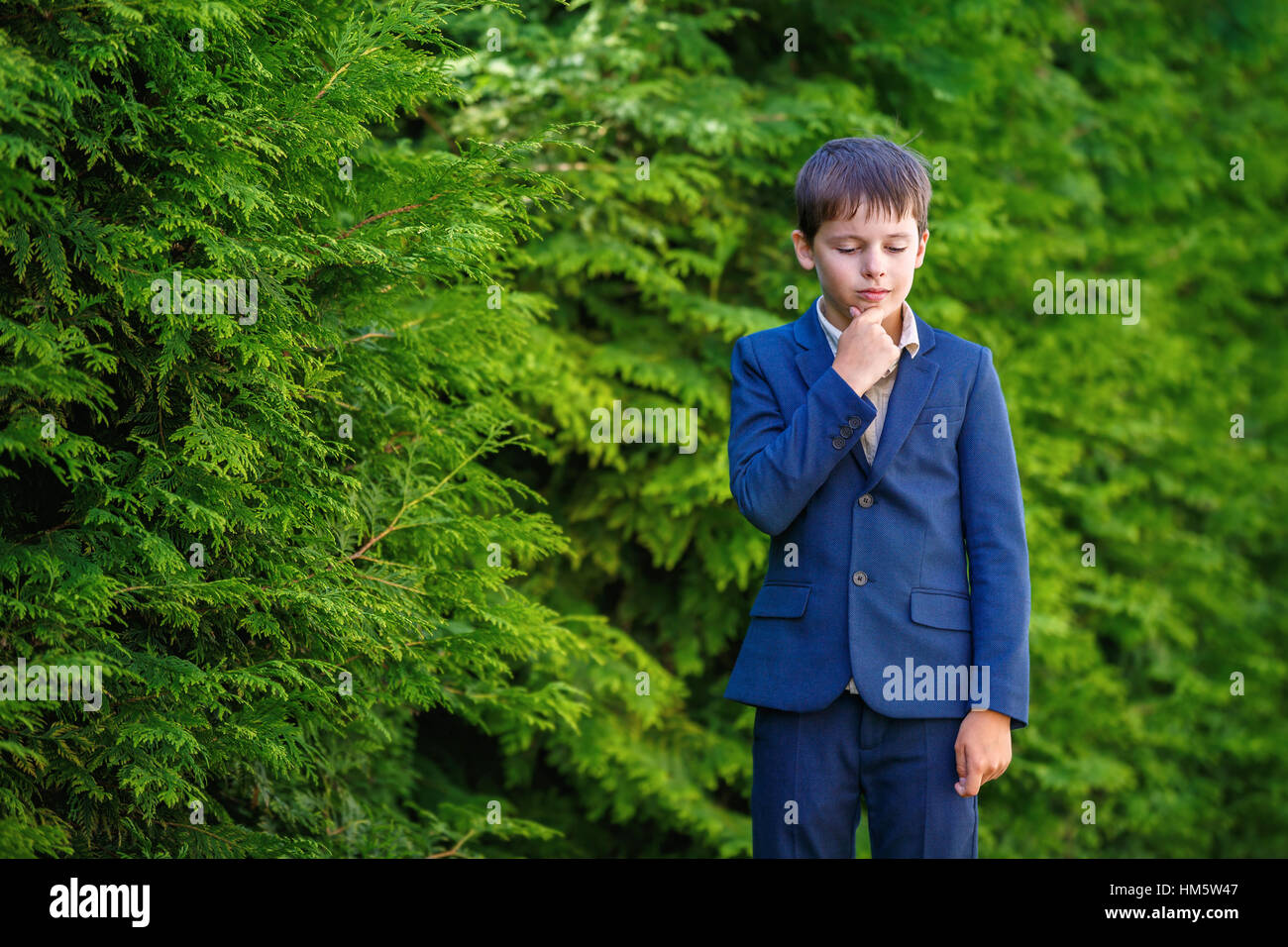 Niedliche kleine Junge in dunklen klassischen Anzug im freien Stockfoto