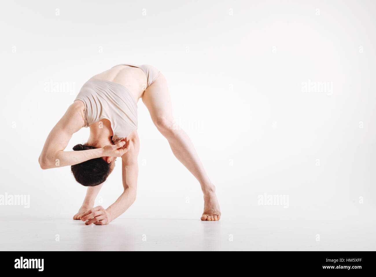 Flexile junge Frau, die ihre Flexibilität im Studio demonstrieren Stockfoto