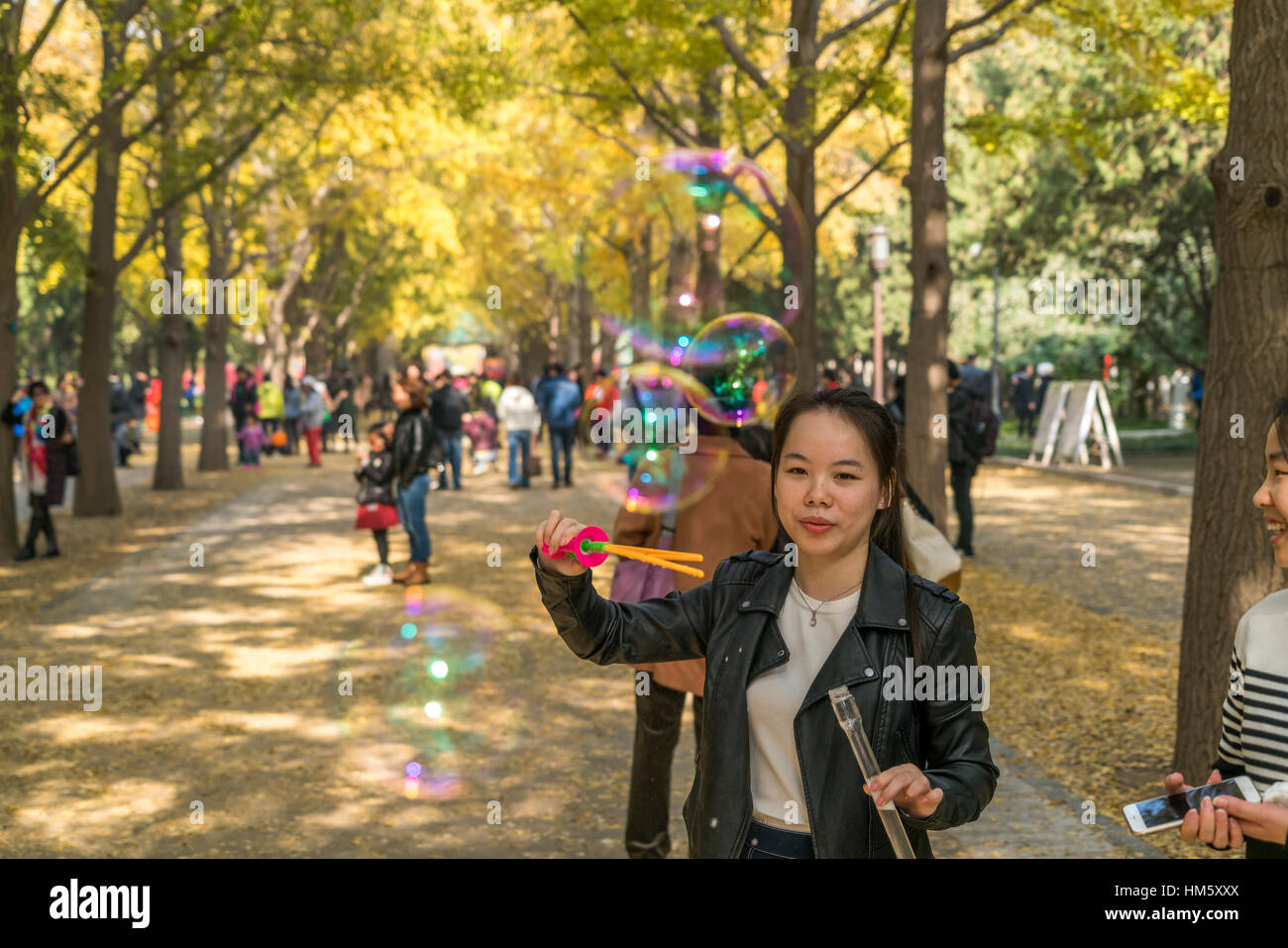Frau bläst Seifenblasen in den Tempel der Erde Park oder Ditan Park in Peking, Volksrepublik China, Asien Stockfoto