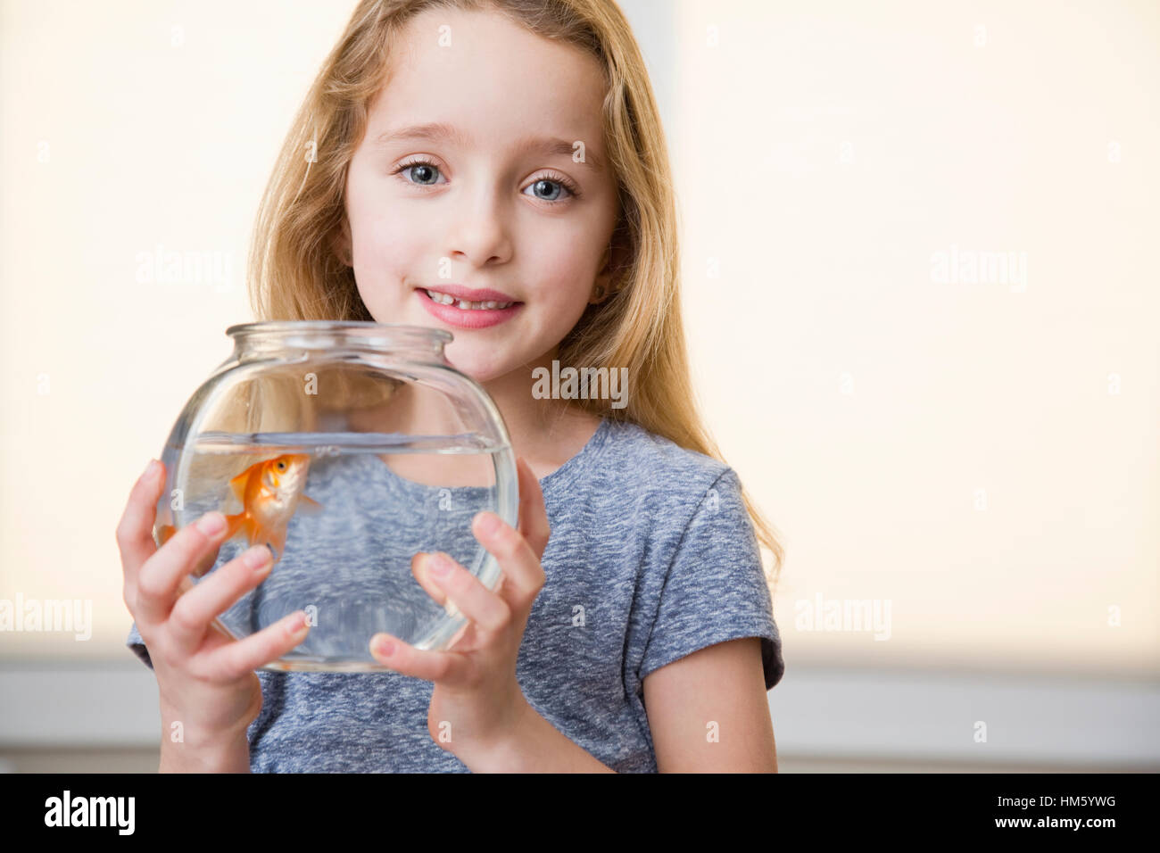 Porträt von Mädchen (6-7) Holding Goldfisch im Goldfischglas Stockfoto