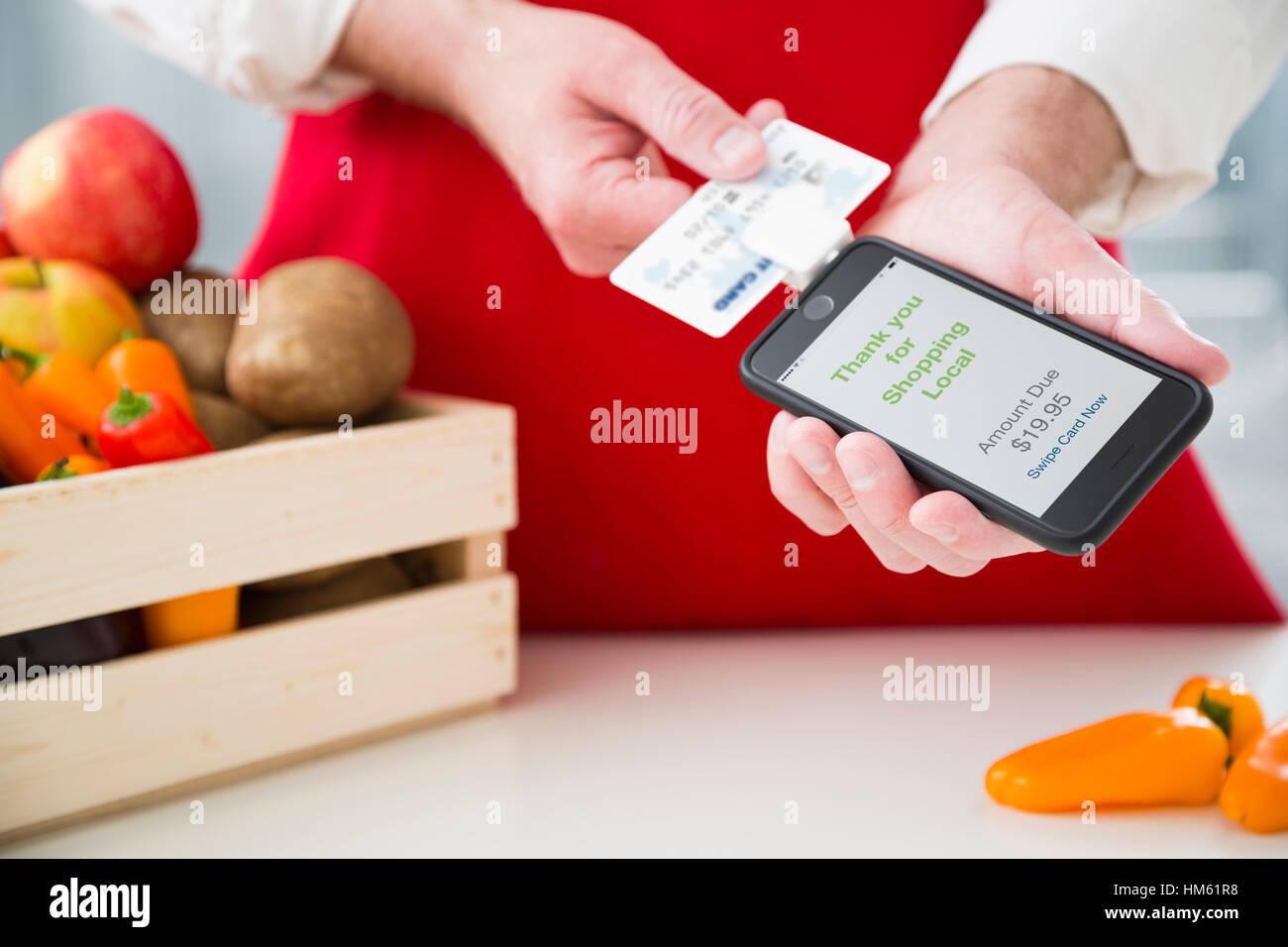 Mann, die Erhebung von Gebühren für Gemüse mit Kreditkarte und smartphone Stockfoto