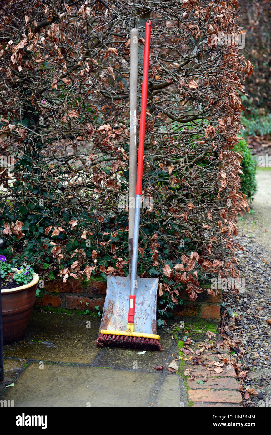 Pinsel und Schaufel Gartenwerkzeug-Tools implementiert aufräumen ordentlich stehen gegen Hecke Herbst Wintergärten Gartenarbeit RM Floral Stockfoto
