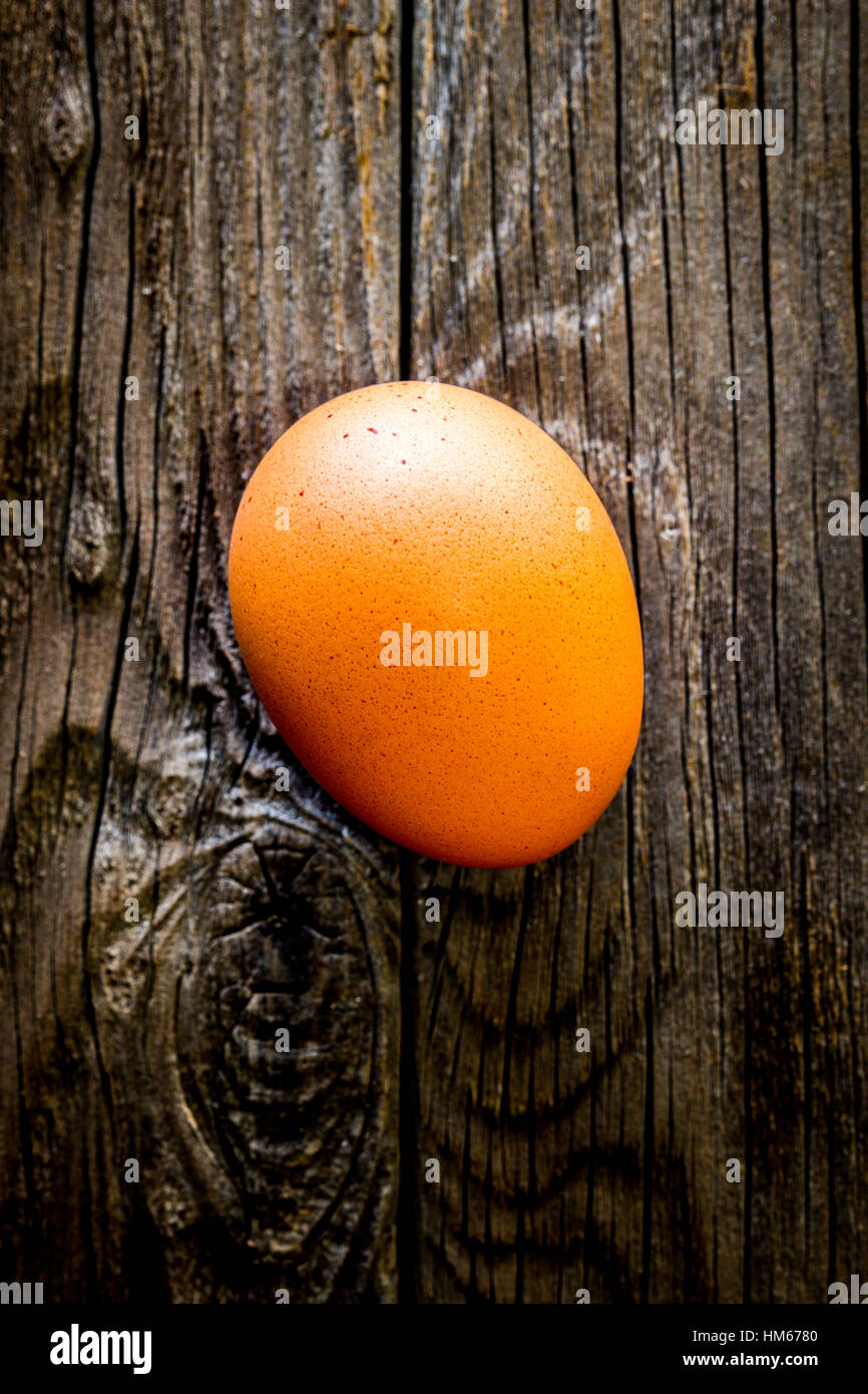 Ein einziges Ei auf einem rustikalen Holztisch Stockfoto