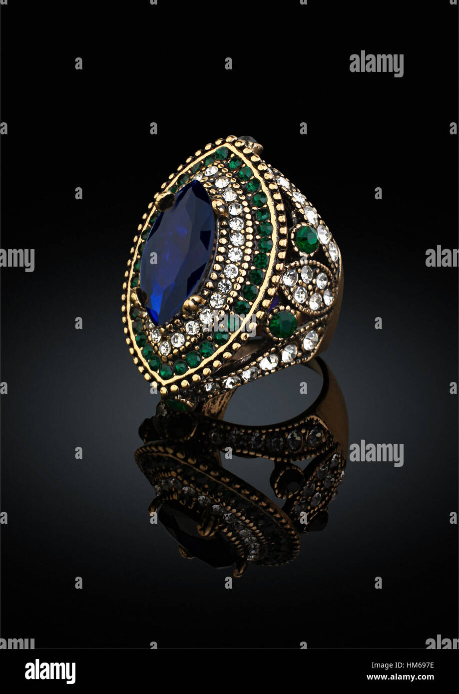 Goldener Ring mit Edelsteinen und Diamanten auf schwarz Stockfoto