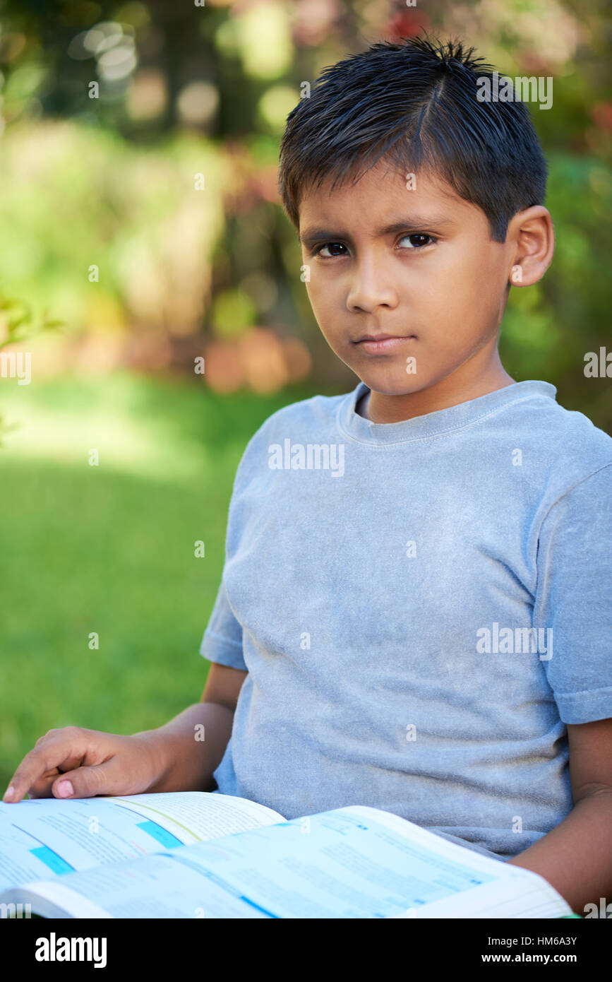 Kind mit einem Buch und schaut in die Kamera Stockfoto