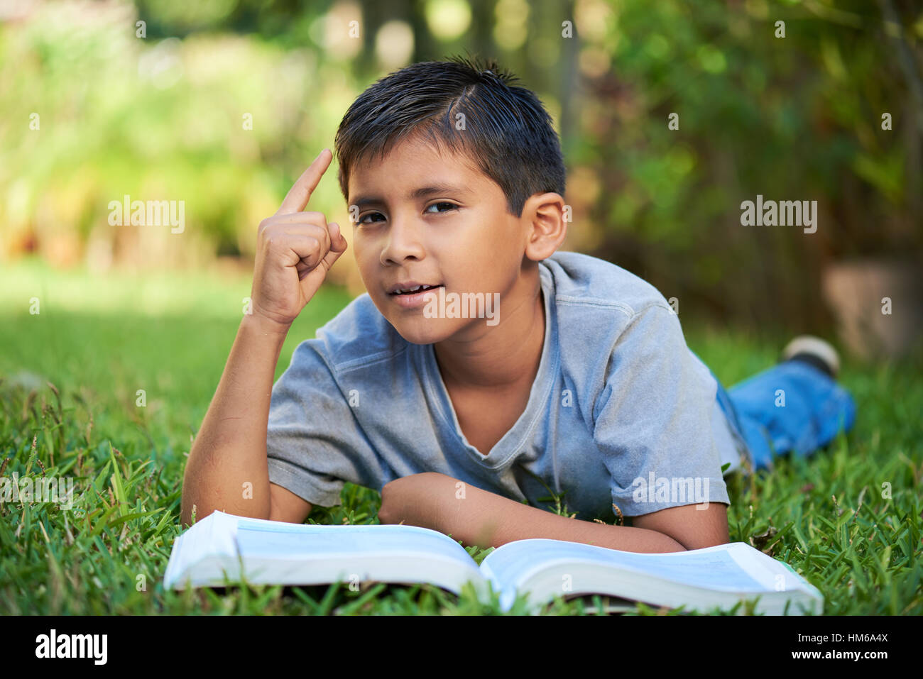 Junge mit einer Idee beim Lesen eines Buches Stockfoto