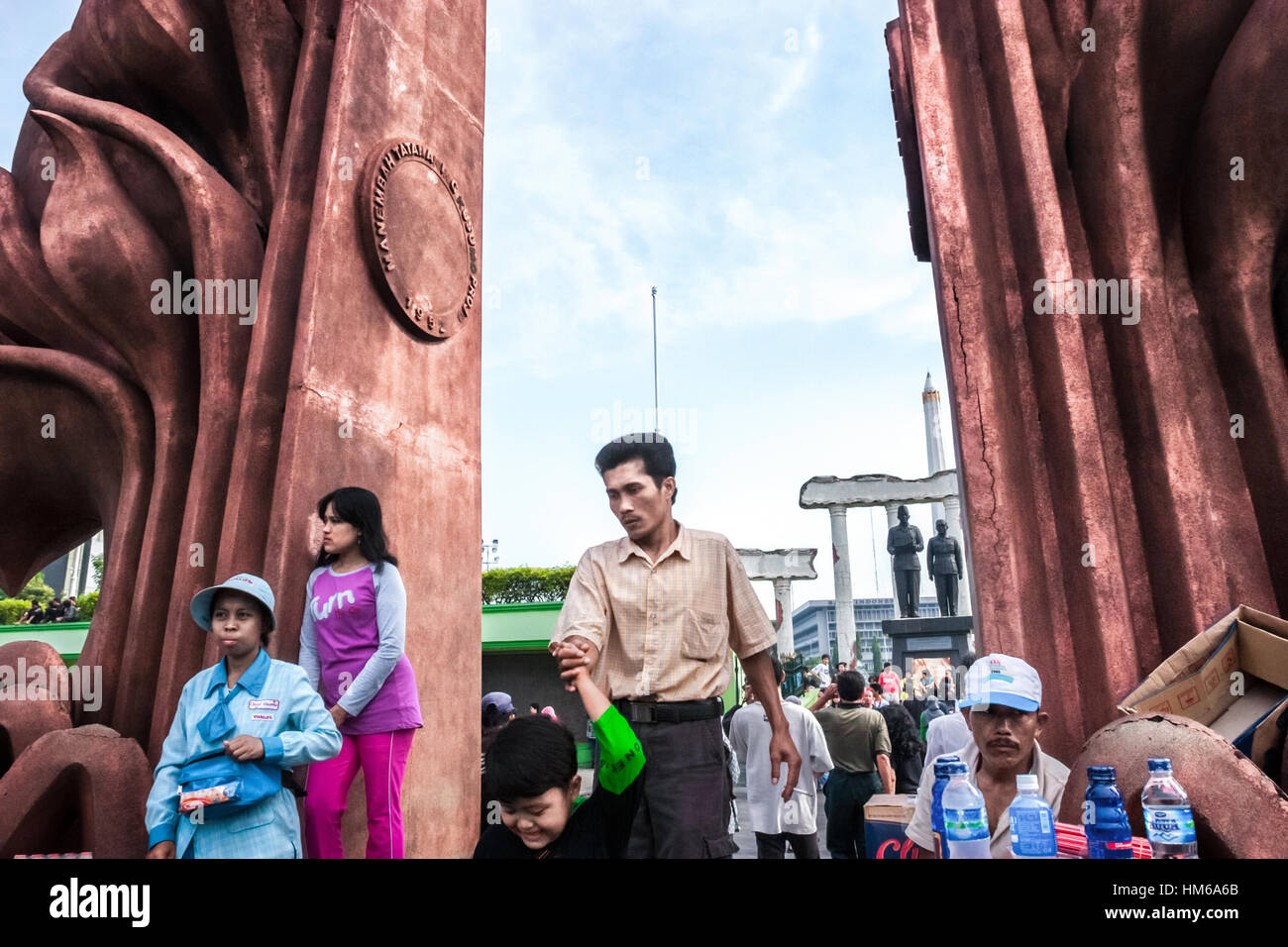 Menschen, die sich in der Nähe des Heroes Monument (10. November Monument) und der Soekarno-Hatta Statue in Surabaya, Ost-Java, Indonesien, Freizeit nehmen. Stockfoto