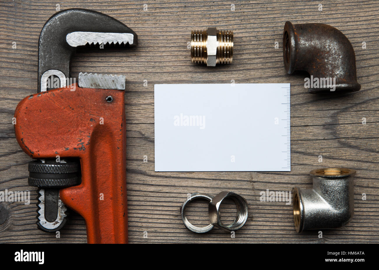 Satz von Rohren Sanitär-Werkzeuge-Beschläge und Visitenkarte auf dem hölzernen Hintergrund Stockfoto