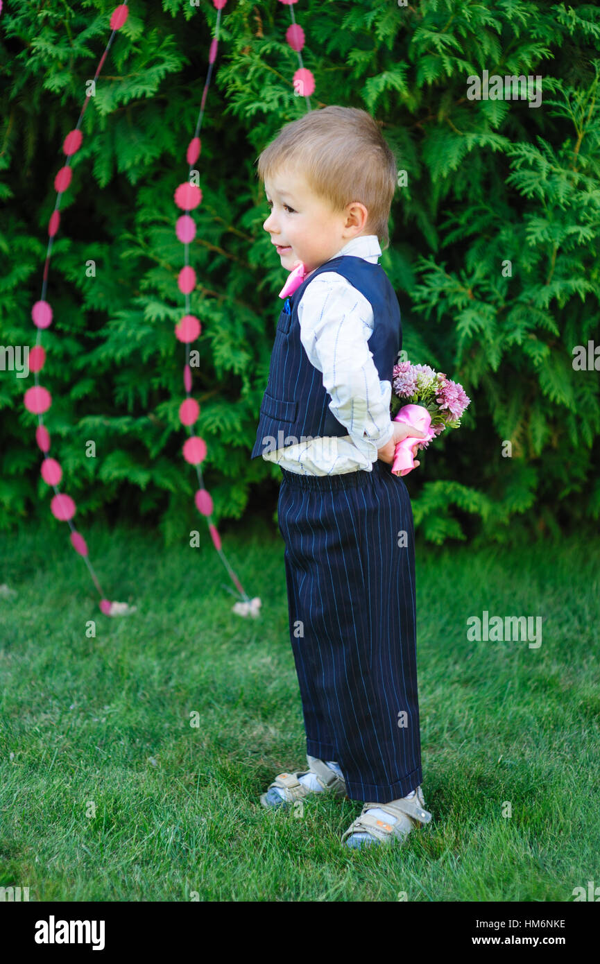 kleiner Junge hält einen Blumenstrauß im park Stockfoto