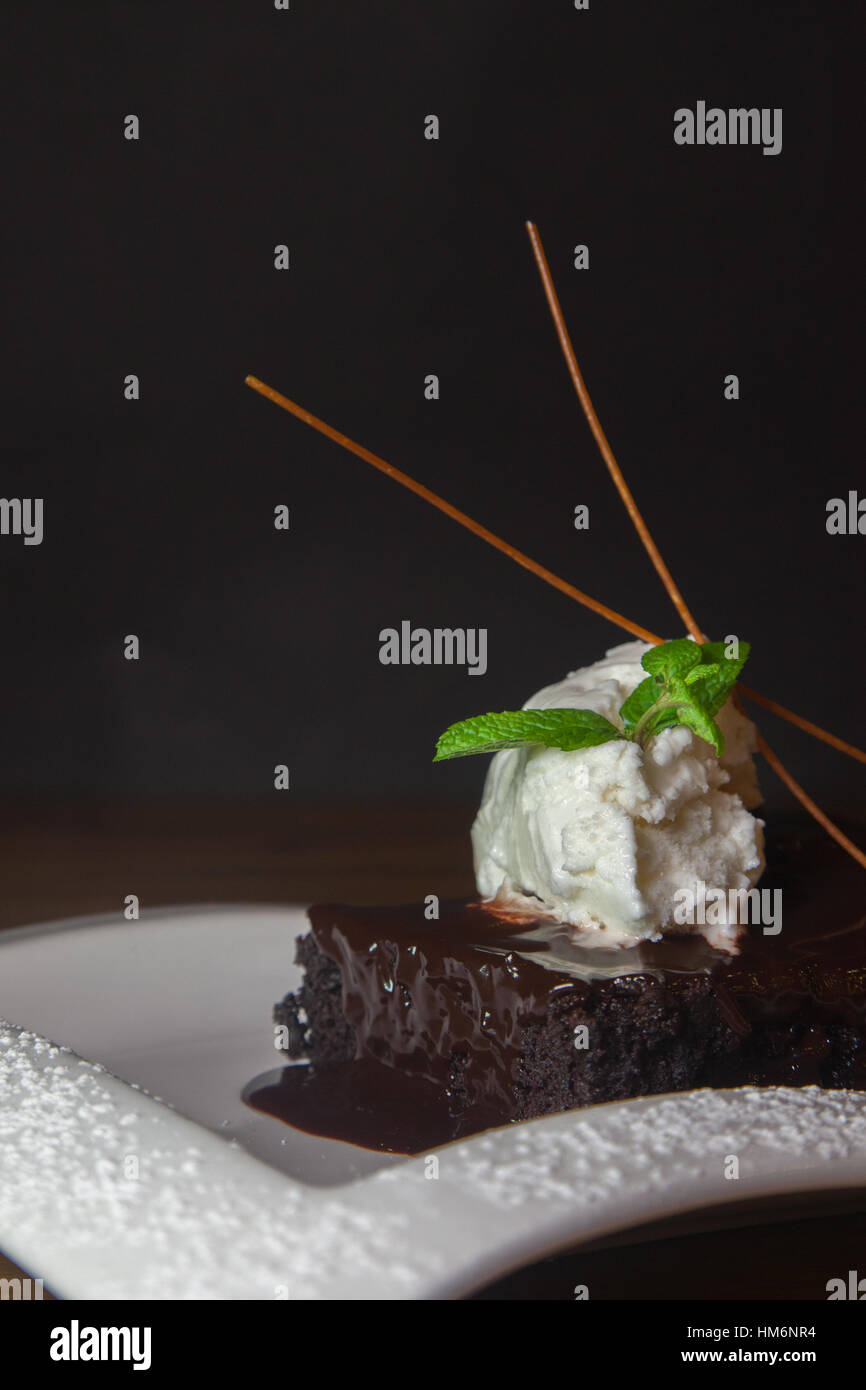 Nahaufnahme von Schokolade Kuchen mit Eis und schwarzem Hintergrund Stockfoto