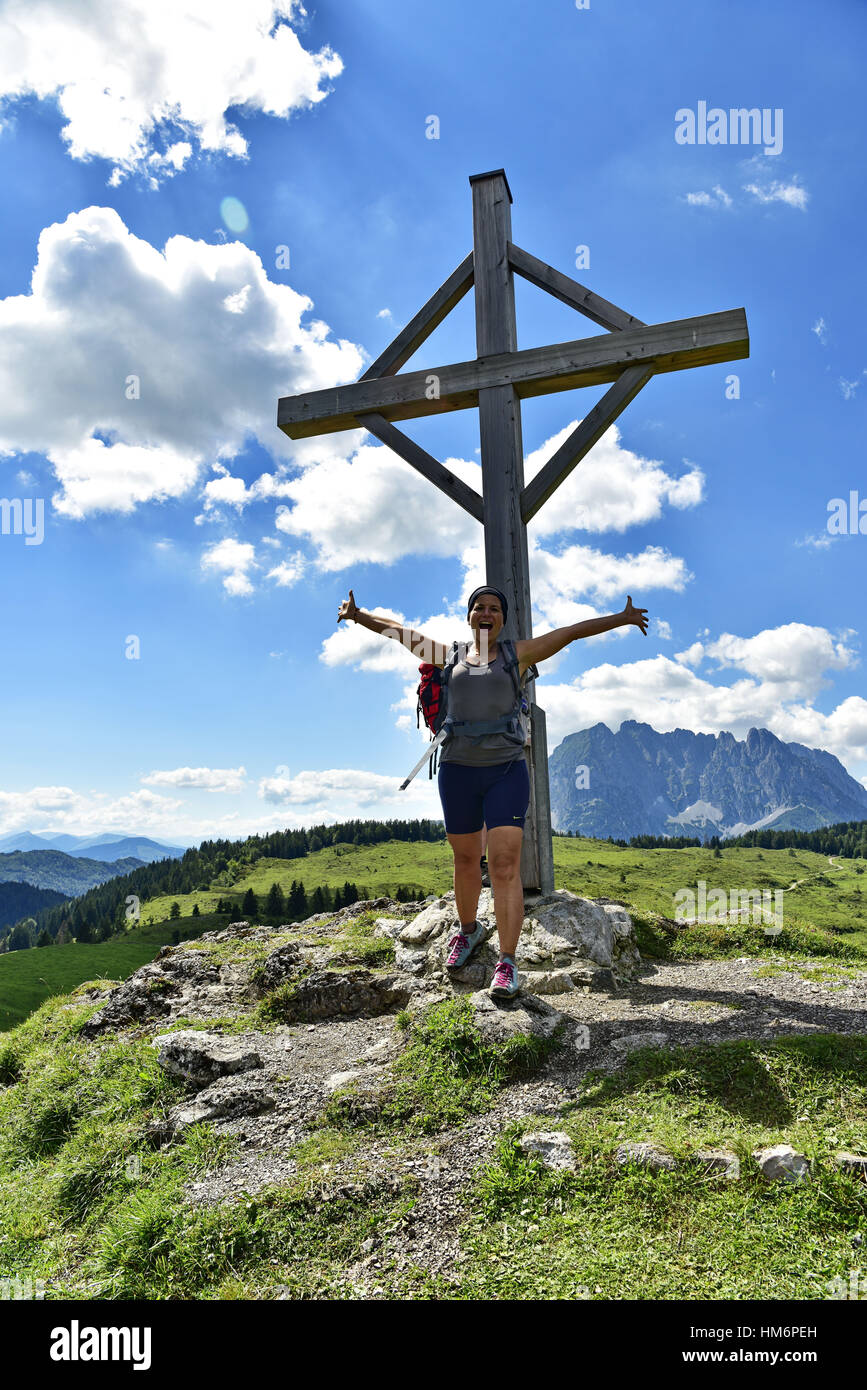 junge Frau steht auf Prost Kogel Gipfel Kreuz Stockfoto
