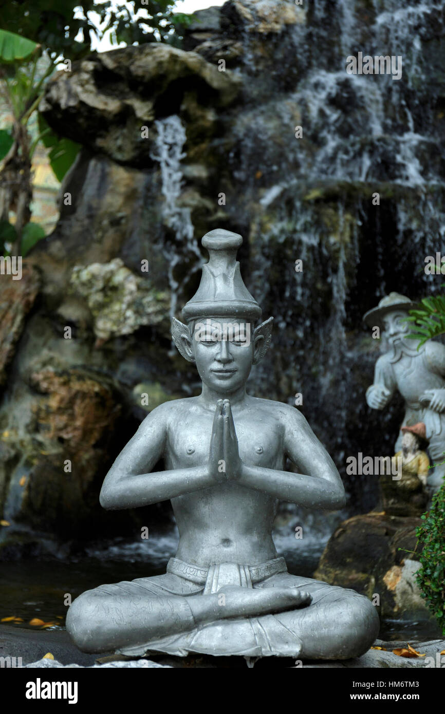 Buddha-Statue gegen künstliche Wasserfall Stockfoto