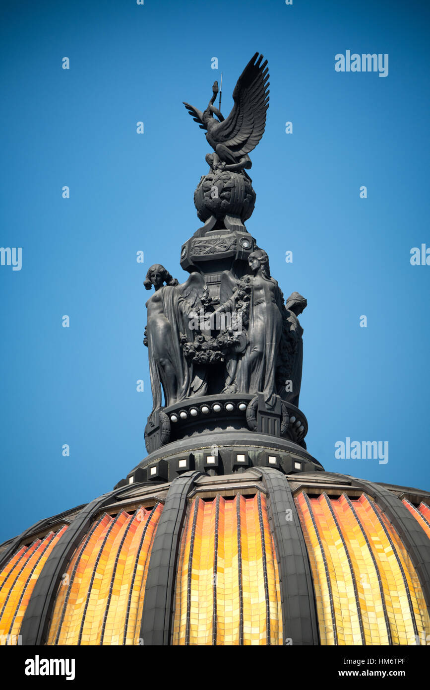 MEXIKO-STADT, Mexiko – Statuen auf der Hauptkuppel des Palacio de Bellas Artes in Mexiko-Stadt. Oben ist ein mexikanischer Adler. Darunter befindet sich eine Reihe von Figuren, die die dramatische Kunst repräsentieren. Der Palacio de Bellas Artes beherbergt Mexikos Nationaltheater. Mit einem Äußeren, das eine Mischung aus Neo Classicical und Art Nouveau Stil ist, und einem Interieur, das Art Deco ist, gilt es weithin als das schönste Gebäude in Mexiko-Stadt. Sie stammt aus dem frühen 20. Jahrhundert und befindet sich im historischen Viertel Centro von Mexiko-Stadt, das zum UNESCO-Weltkulturerbe gehört. Stockfoto