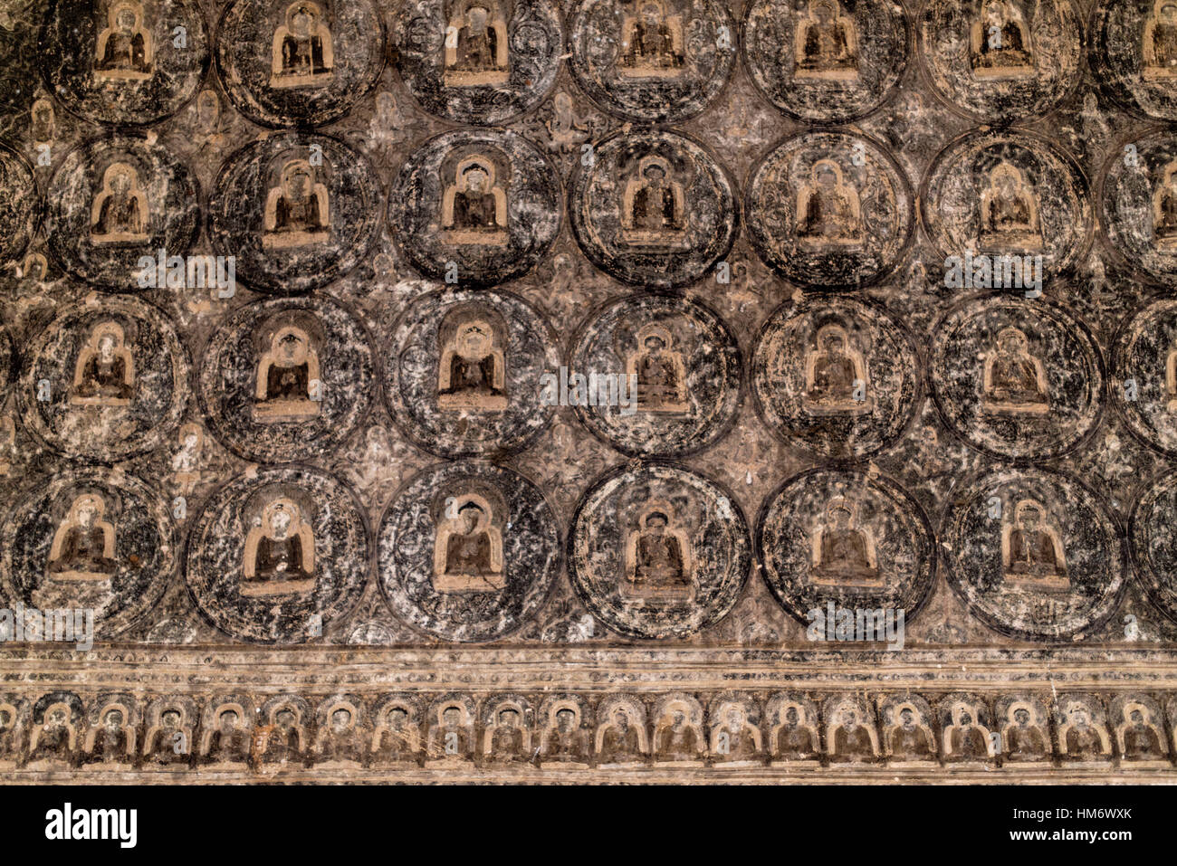 Lemyethna Tempelfresken Bagan Myanmar // BAGAN, Myanmar — komplizierte Fresken aus kleinen, fliesenartigen Illustrationen, die geometrische Muster erzeugen, zieren die Innenwände und Decken des Lemyethna Tempels (auch bekannt als Lemyethna Pagode), eines buddhistischen Tempels, der 1223 n. Chr. während der Herrschaft von König Htilominlo erbaut wurde. Der Tempel wurde von Anandathura, einem Minister am königlichen Hof, erbaut und verfügt über eine quadratische Basis mit aufwendigen Stuckverzierungen und vier Schreine mit Buddha-Statuen, die nach Kardinalrichtungen gerichtet sind. Das Dekorationsprogramm des Tempels beinhaltete ursprünglich umfangreiche Wandmalereien depic Stockfoto