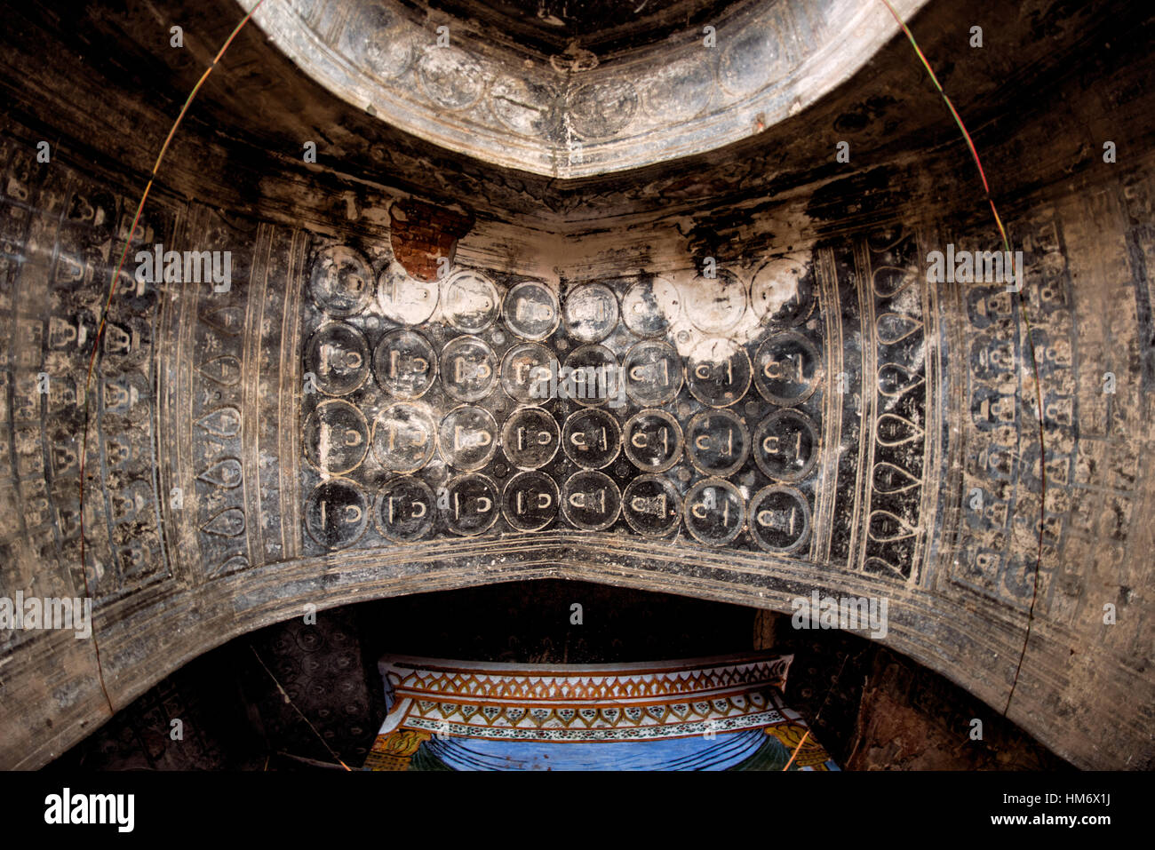 Lemyethna Tempelfresken Bagan Myanmar // BAGAN, Myanmar — komplizierte Fresken aus kleinen, fliesenartigen Illustrationen, die geometrische Muster erzeugen, zieren die Innenwände und Decken des Lemyethna Tempels (auch bekannt als Lemyethna Pagode), eines buddhistischen Tempels, der 1223 n. Chr. während der Herrschaft von König Htilominlo erbaut wurde. Der Tempel wurde von Anandathura, einem Minister am königlichen Hof, erbaut und verfügt über eine quadratische Basis mit aufwendigen Stuckverzierungen und vier Schreine mit Buddha-Statuen, die nach Kardinalrichtungen gerichtet sind. Das Dekorationsprogramm des Tempels beinhaltete ursprünglich umfangreiche Wandmalereien depic Stockfoto
