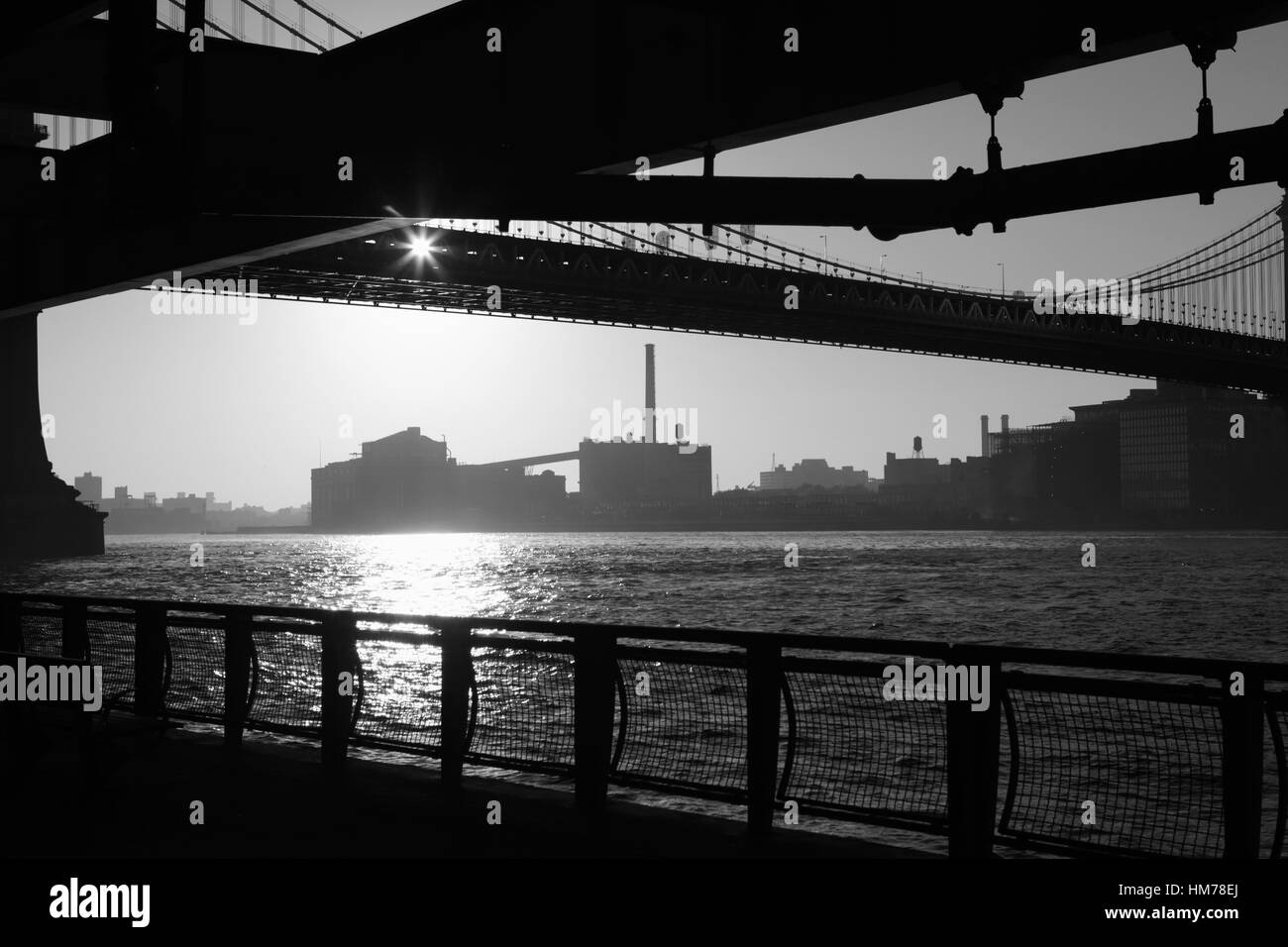 Blick vom East River Esplanade der Brooklyn Uferpromenade unter der Manhattan Bridge über den East River bei Sonnenaufgang Stockfoto