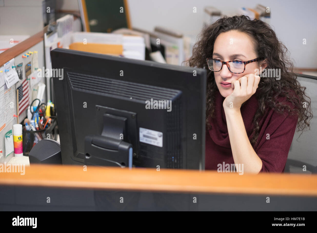 Junge Frau, die am Computer-monitor Stockfoto