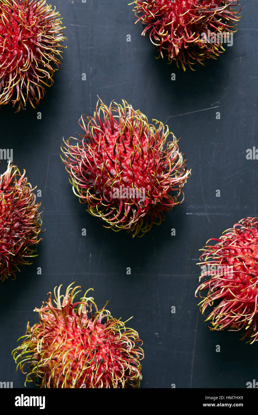 Rambutan (Nephelium Lappaceum) Früchte auf graue Oberfläche Stockfoto