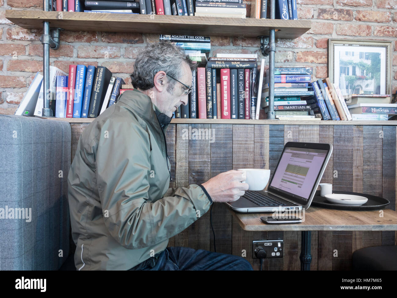Reifer Mann mit Laptop im Pub. Stockfoto