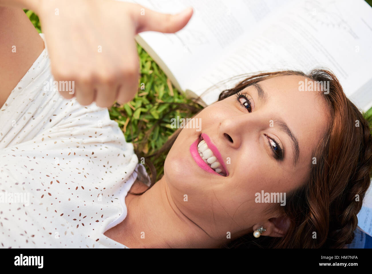 Mädchen tun Daumen nach oben während zur Festlegung auf Bücher Stockfoto