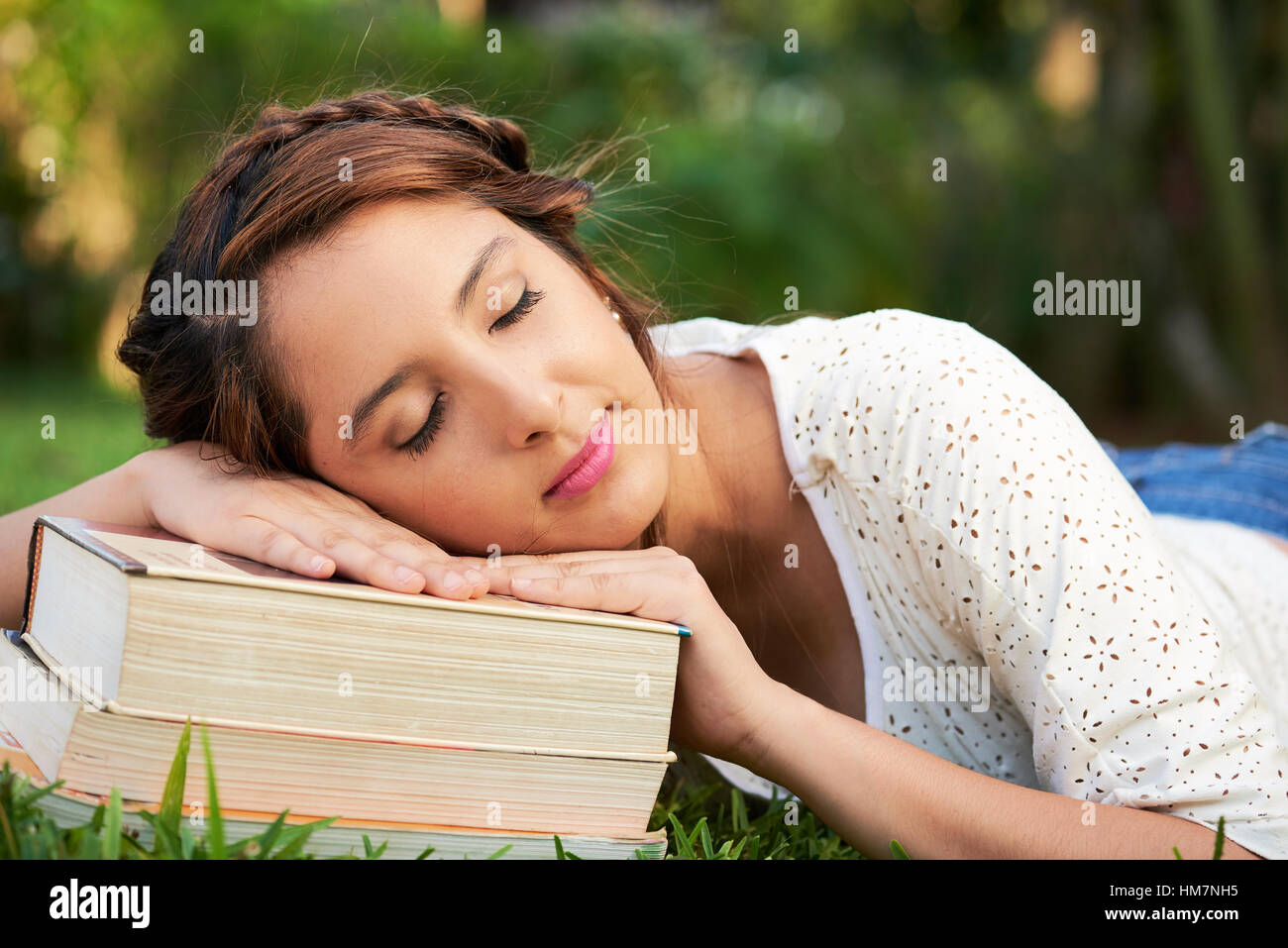 Mädchen beim Einschlafen während des Studiums für eine Prüfung im freien Stockfoto