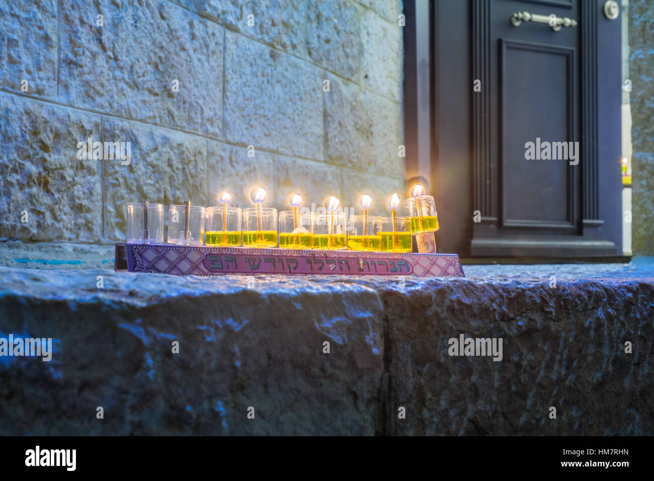 Traditionelle Menorah (Chanukka Lampe) mit Olivenöl Kerzen, set für Anzeige nahe dem Eingang in das jüdische Viertel, Altstadt von Jerusalem, Israel. Text Stockfoto