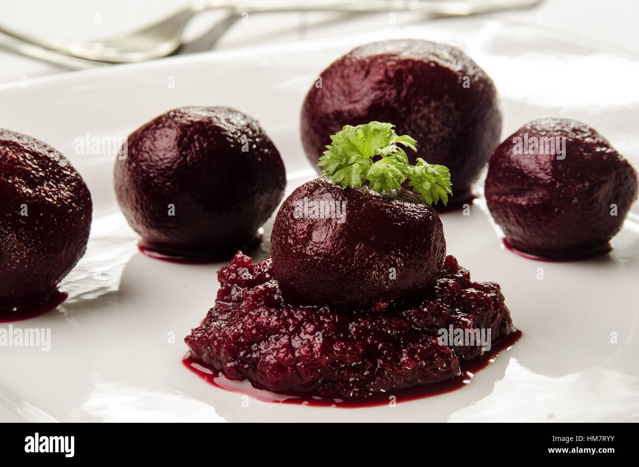 Rote Bete Kugeln und Püree mit frischer Petersilie auf einem weißen Teller Stockfoto