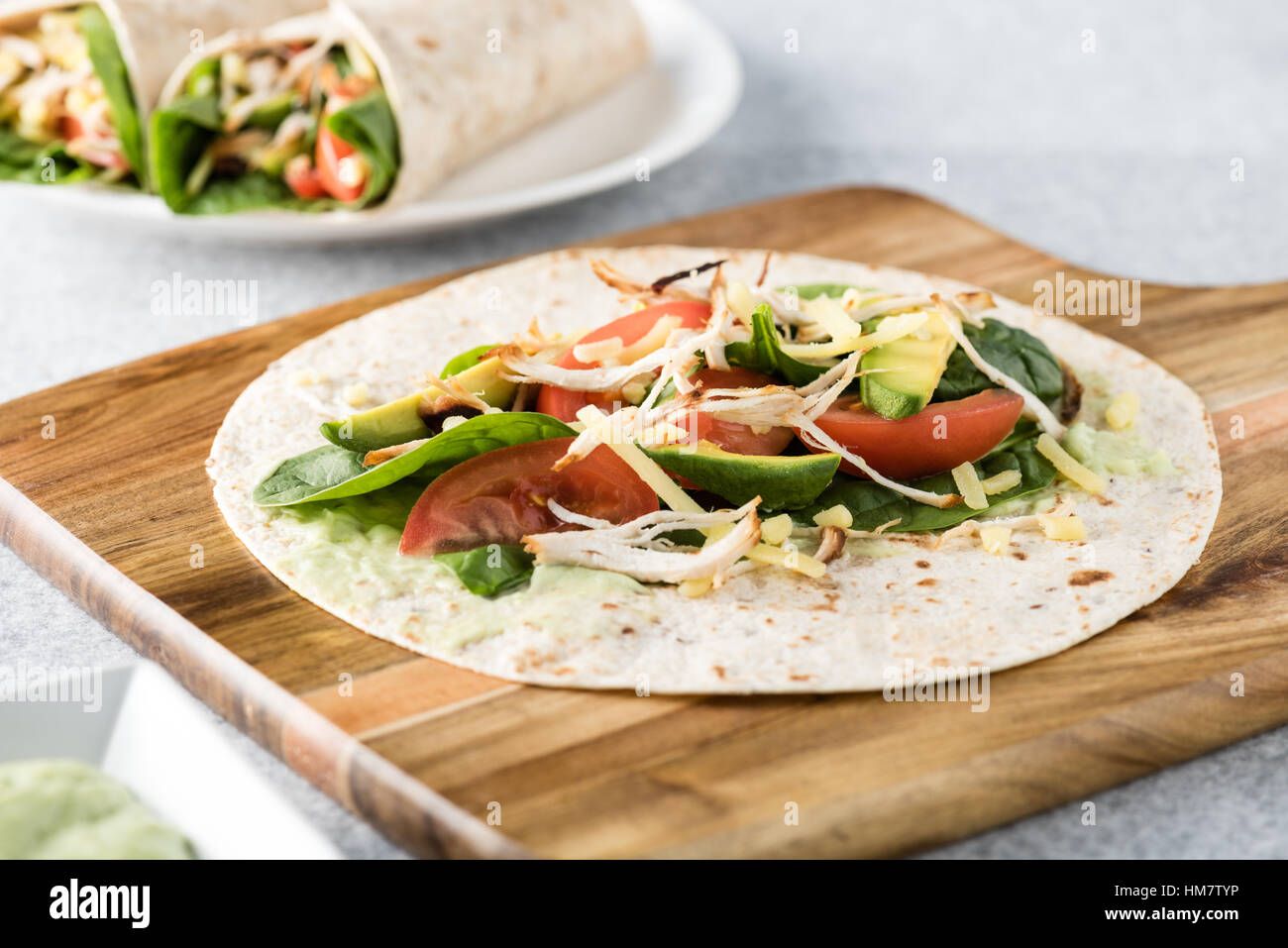 Gegrilltes Hühnerfleisch wraps mit Karotte, Käse, Avocado und Spinat. Mit Pommes Frites auf der Seite. Stockfoto