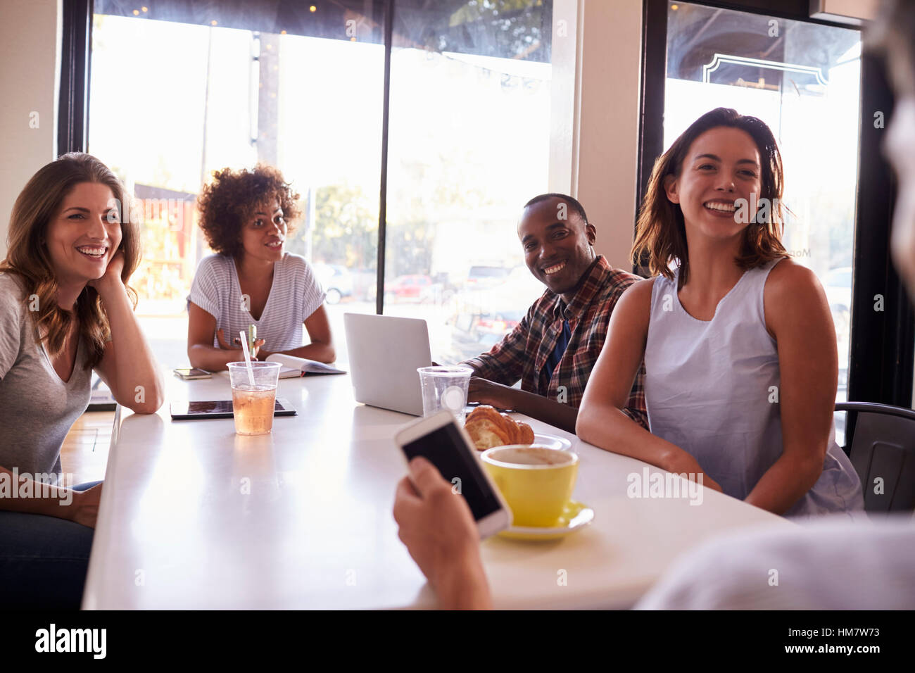 Fünf Erwachsene Freunde sitzen in einem Café, über die Schulter sehen Stockfoto