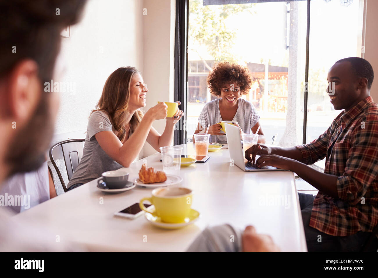 Fünf Erwachsene Freunde sitzen in einem Café, über die Schulter sehen Stockfoto