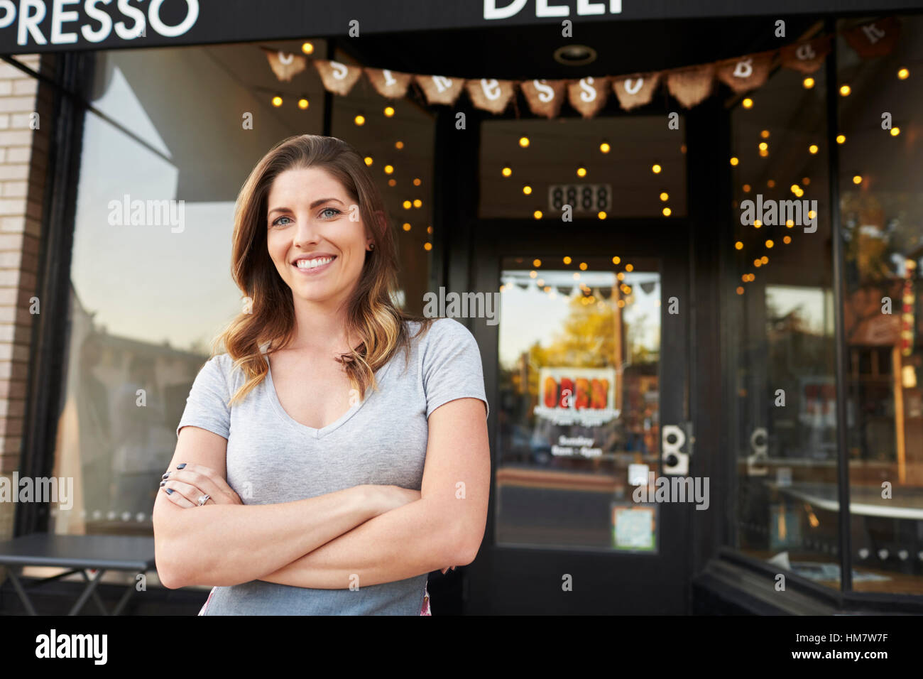 Weibliche Unternehmer steht mit verschränkten Armen außen café Stockfoto