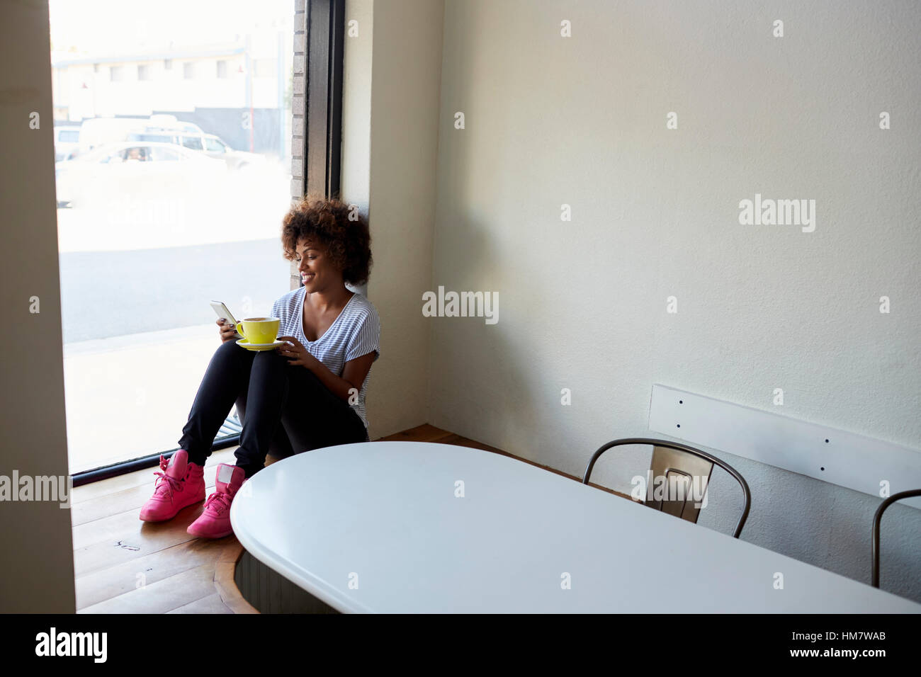 Fotografen, die Bilder von Frau in Café durch Fenster Stockfoto