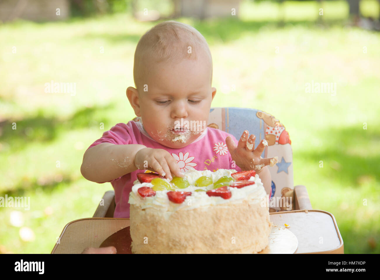 Ein Baby einen Geburtstagskuchen mit den Händen essen Stockfoto