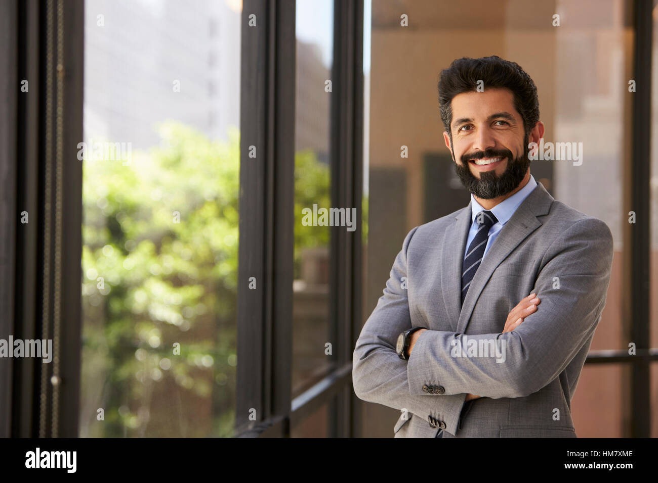 Lächelnd Hispanic Geschäftsmann mit Arme gekreuzt, Kamera Stockfoto