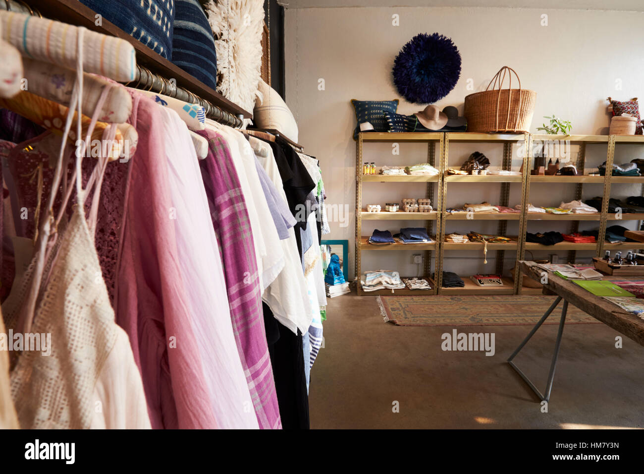 Klamotten, die auf einer Schiene in Kleidung und Accessoires shop Stockfoto