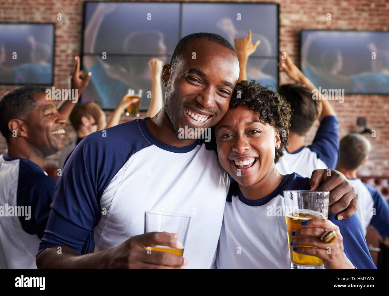 Porträt des Paares Spiel Sports Bar auf Bildschirmen beobachten Stockfoto