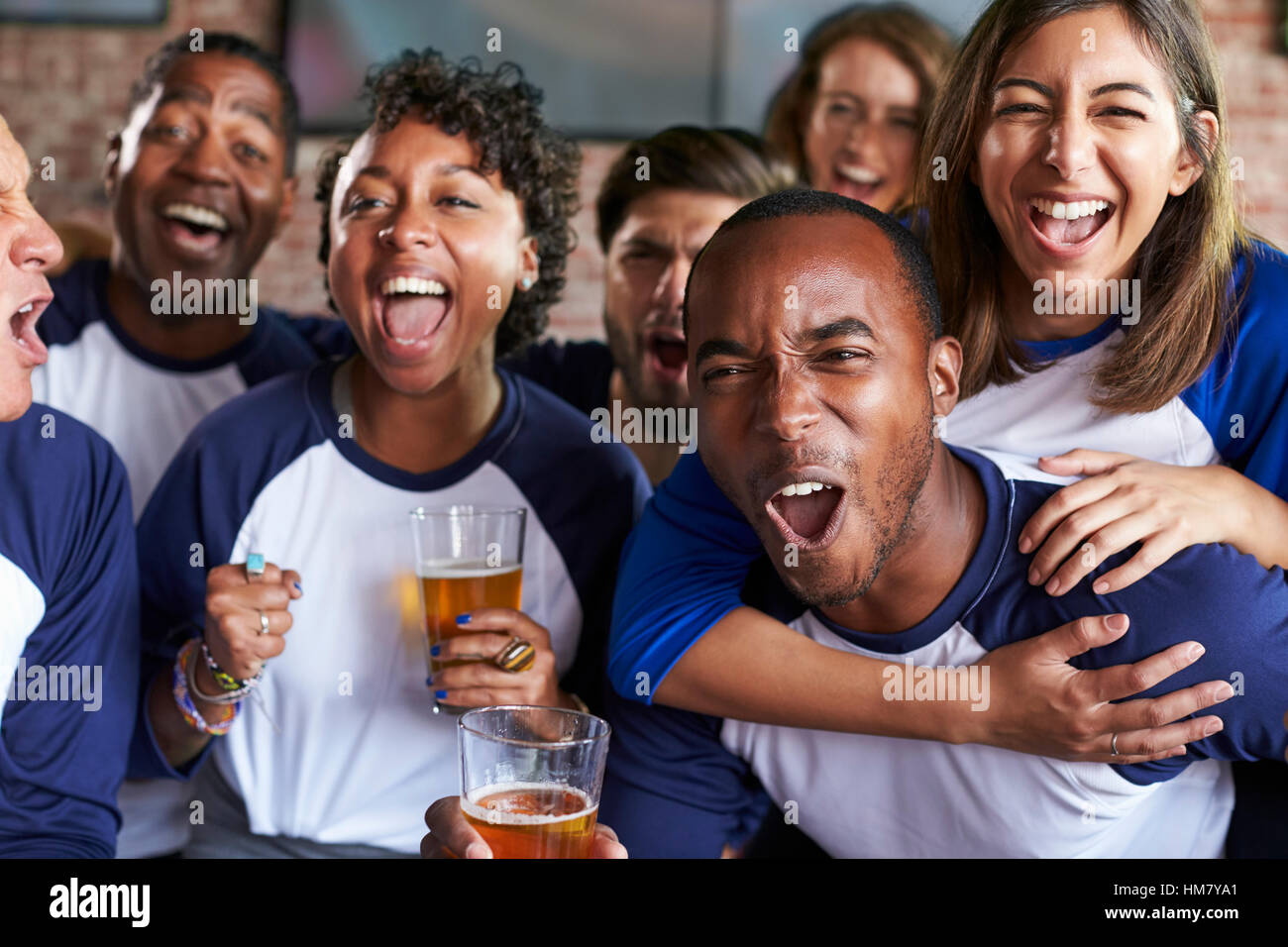 Porträt von Freunden Spiel Sports Bar auf Bildschirmen beobachten Stockfoto