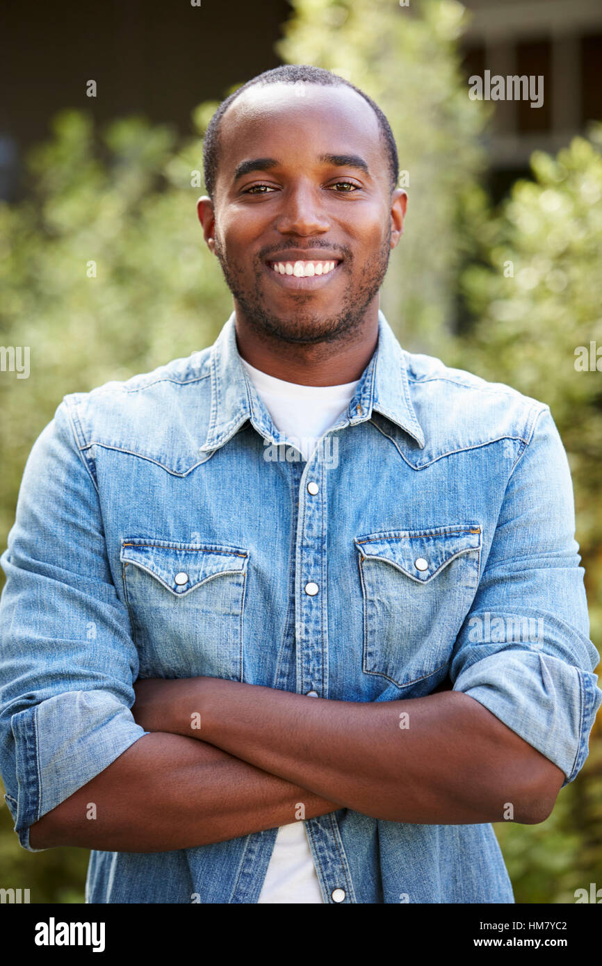 Afrikanische amerikanische Mann in Jeanshemd, verschränkten Armen, vertikal Stockfoto