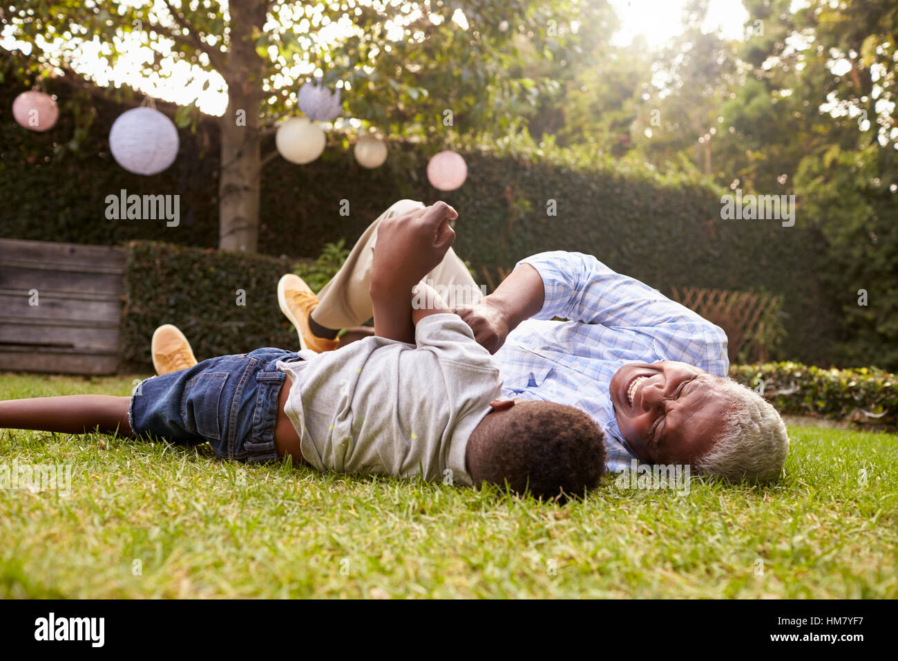 Großvater und Enkel spielen auf Rasen, niedrigen Winkel liegen Stockfoto