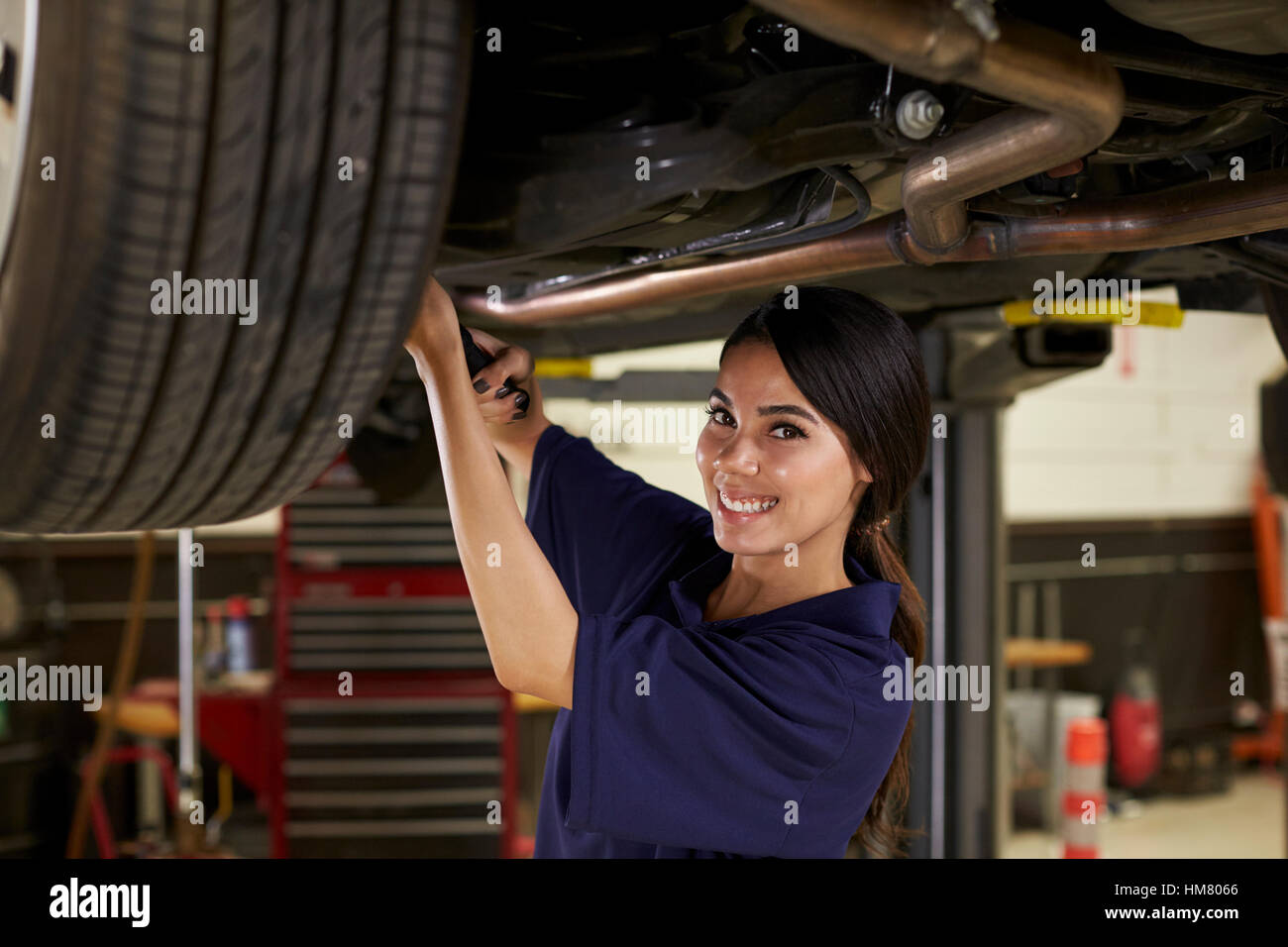 Porträt von weiblichen Auto Mechaniker arbeiten unter Auto Stockfoto