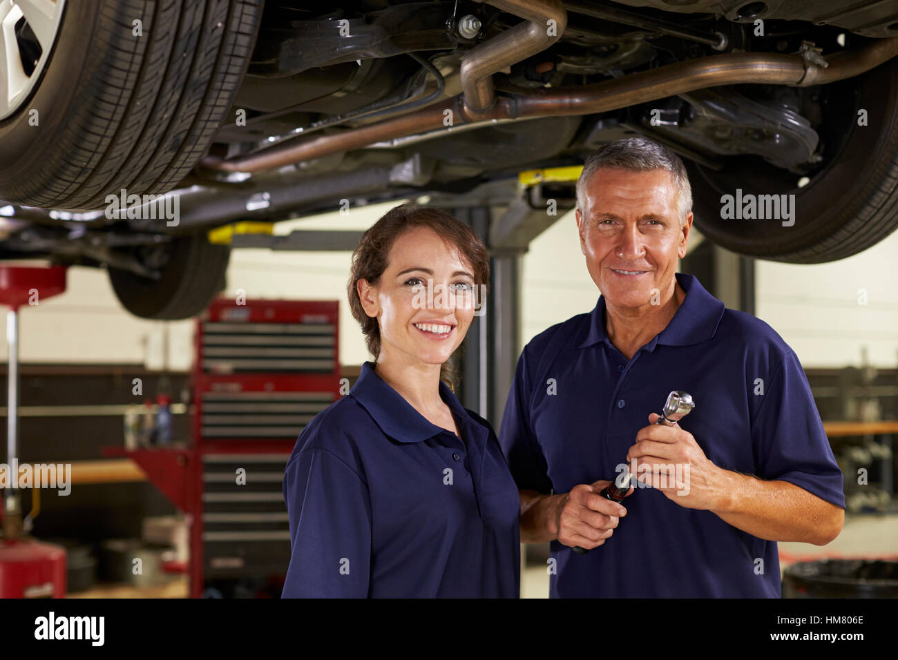 Männliche und weibliche Mechanik gemeinsam unter Auto Stockfoto