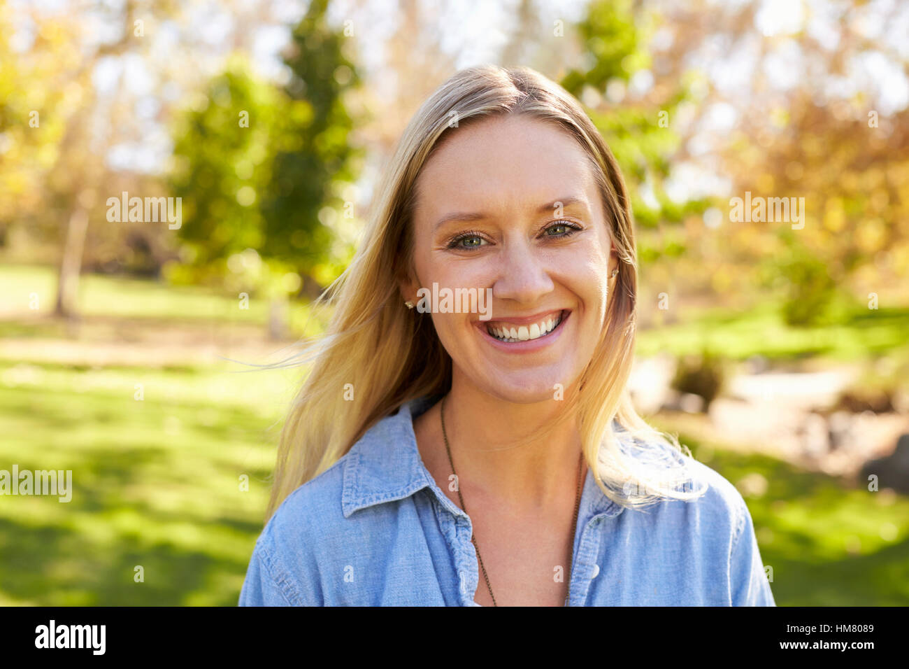 Mitte der dreißiger Jahre weiße Frau Lächeln und Kamera in einem Park Stockfoto